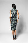 A woman shown from the back wearing a sleeveless top and knee-length skirt with a dark floral print in green, gray, and black tones, paired with black ankle boots, against a light gray studio background.