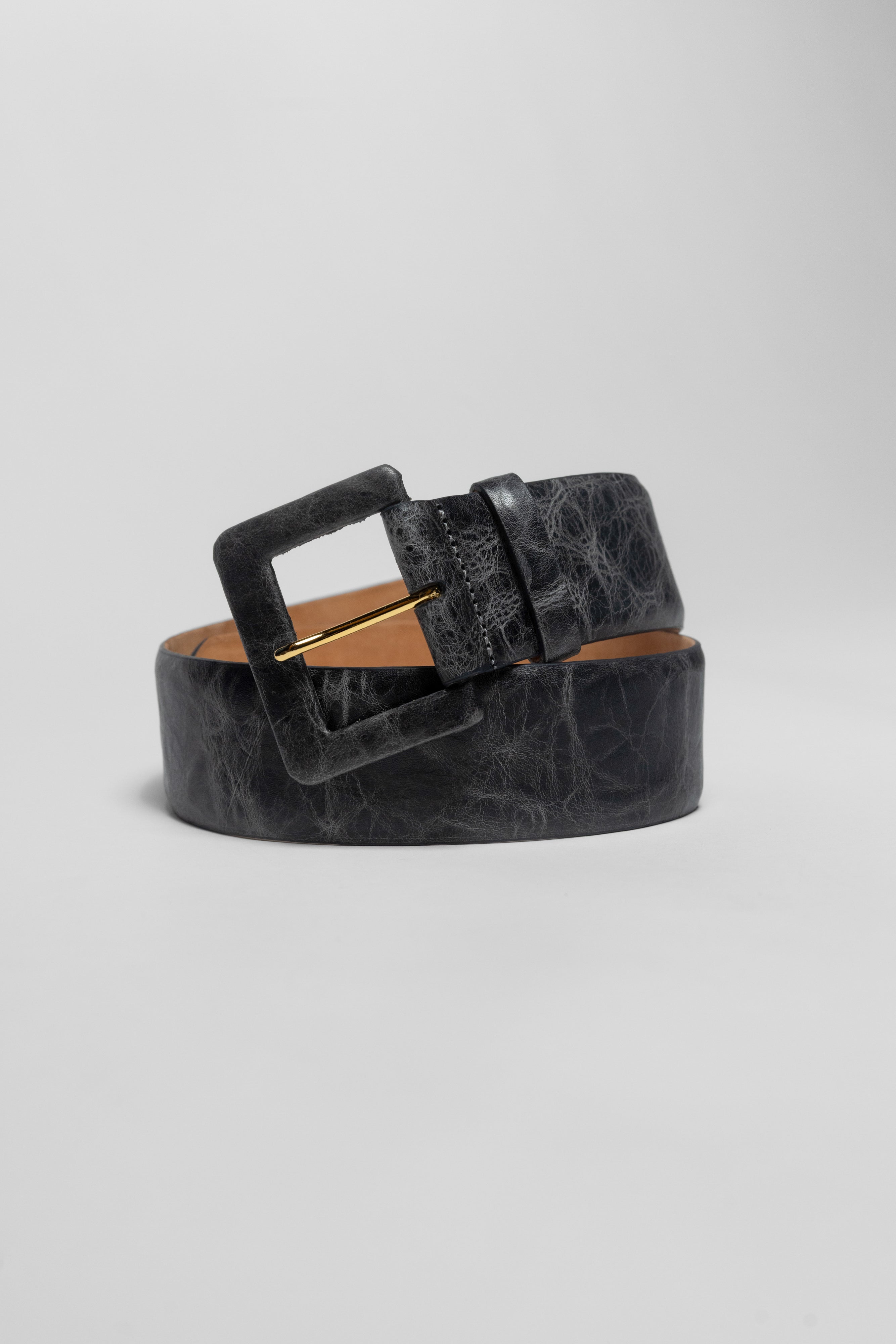 A black textured leather belt with a large square buckle, coiled on a light gray background.