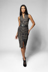 A woman modeling a sleeveless, textured black and gray top and skirt with a wide black belt at the waist, paired with black pointed-toe heels, against a light gray studio background.