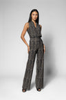 A woman modeling a sleeveless top, wide-leg pants with a textured, abstract black and gray pattern, standing against a light gray studio background.