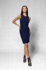 A woman modeling a sleeveless, bodycon navy blue mini dress with side pockets, paired with black lace-up high-heeled sandals, against a light gray studio background.