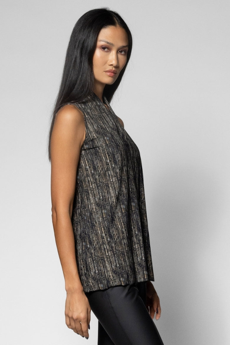 A woman modeling a sleeveless, textured black and gray top against a light gray studio background.